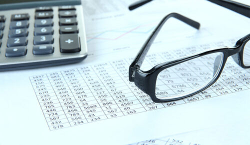 Glasses and calculator on financial spreadsheets